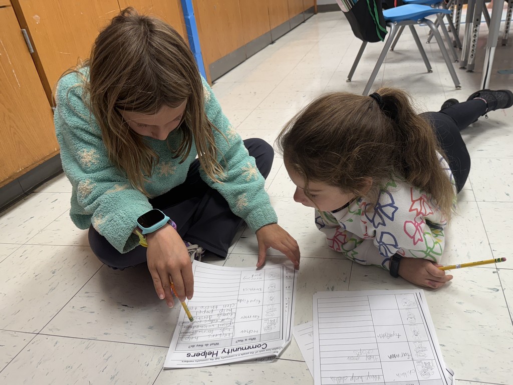 second grade students working together on a community helpers activity