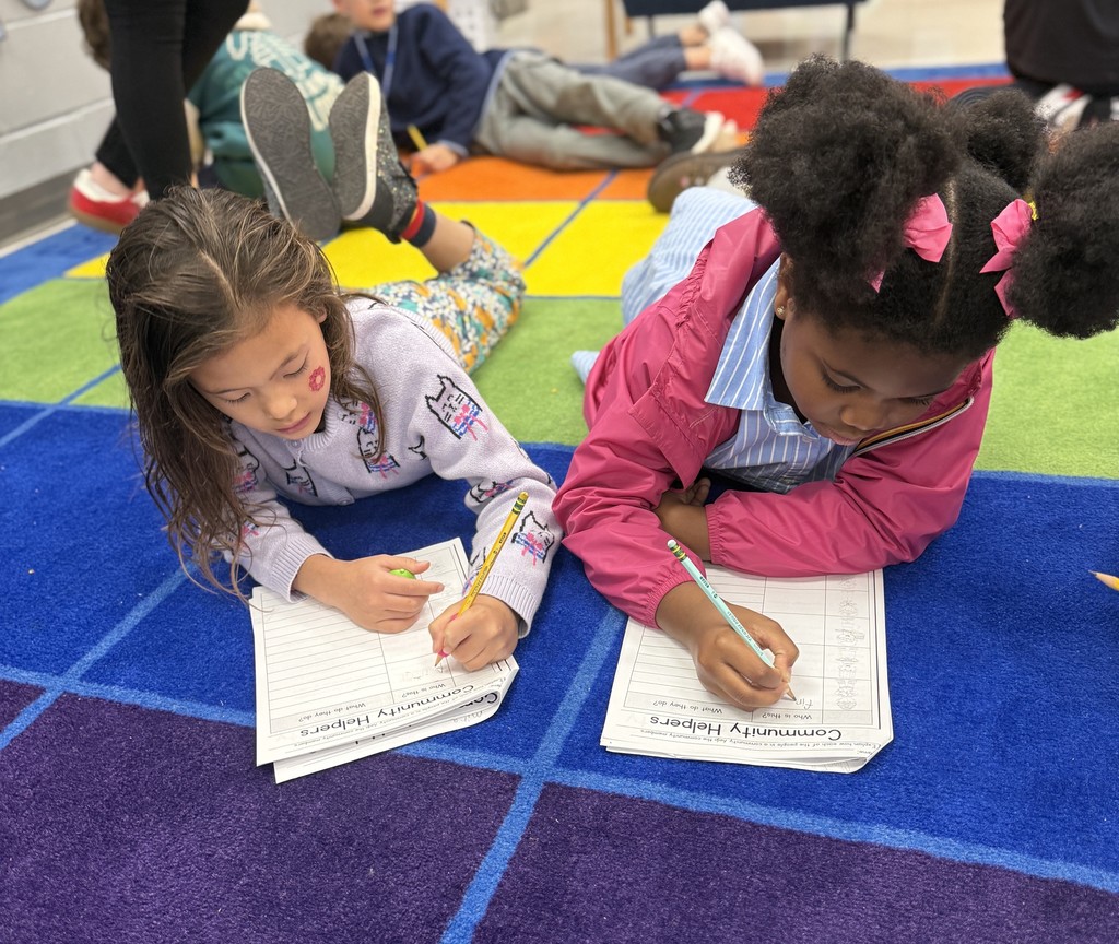 second grade students working together on a community helpers activity