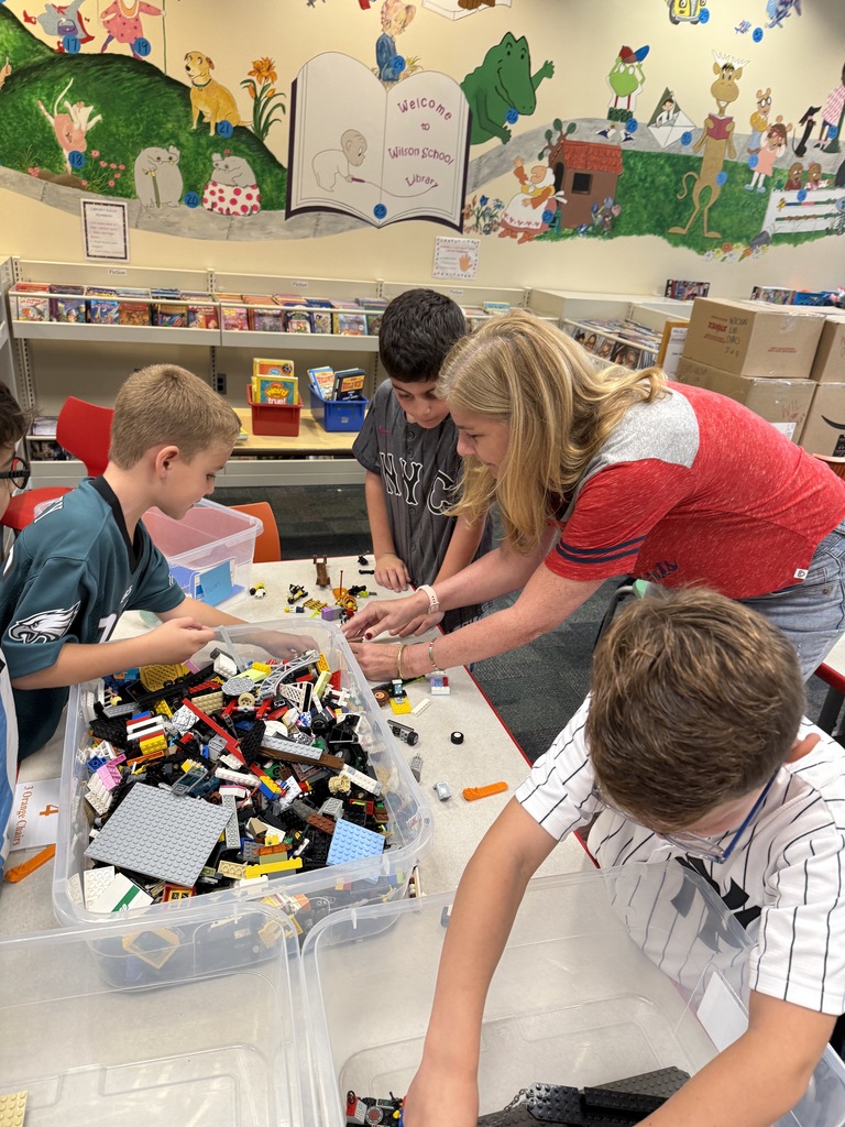 students working on a lego design challenge with teacher