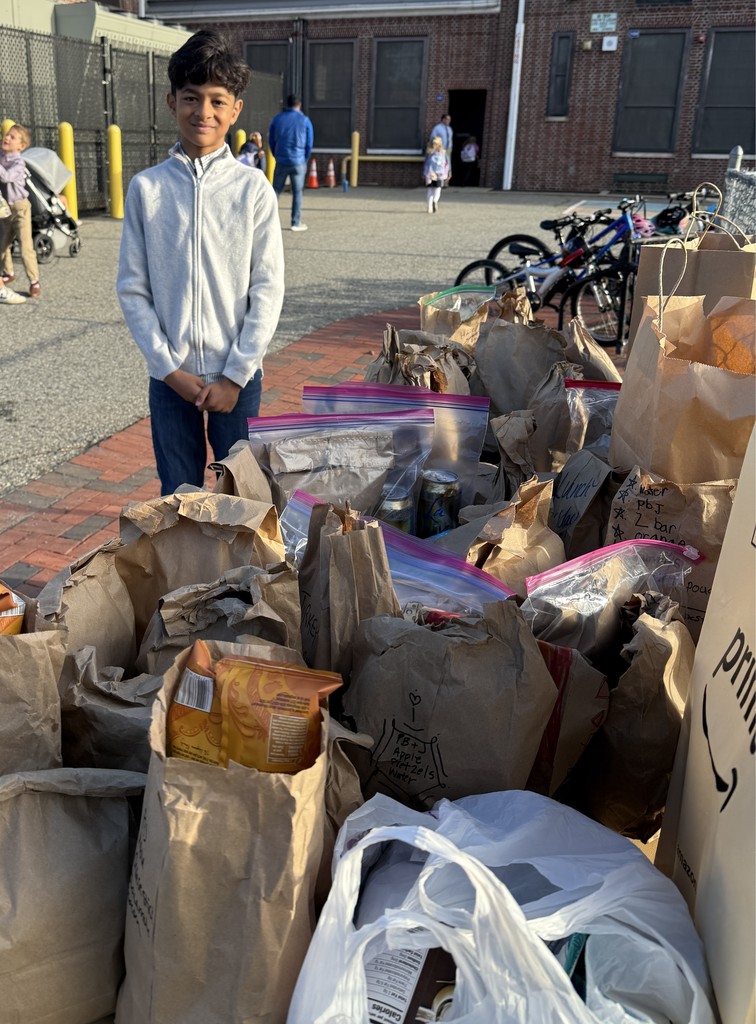student standing by extra lunches  on donation table