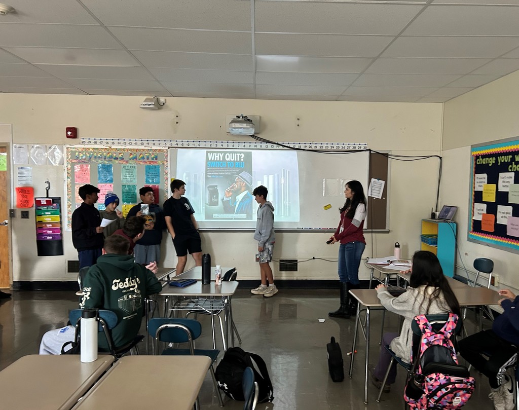 Student presenting advertisement to Ms. Wilson