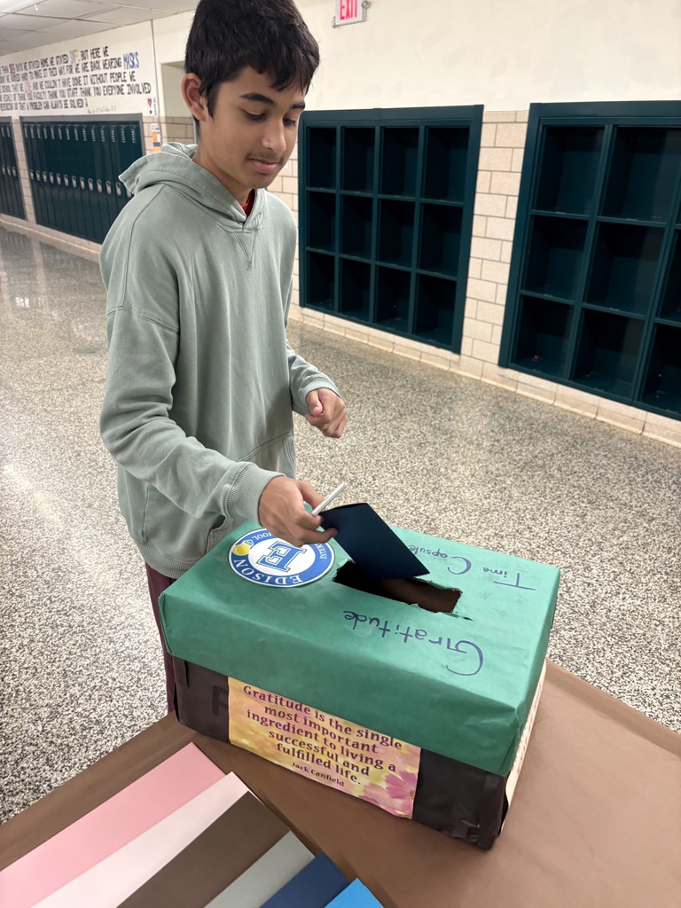 Student adding letter to time capsule 
