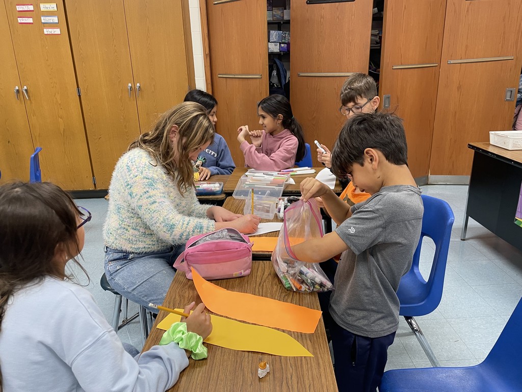 Student buddies decorate the feather together.