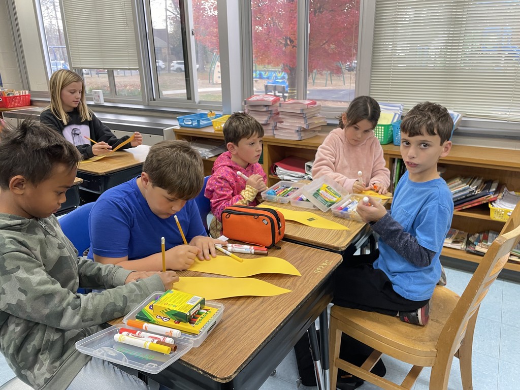 Student buddies decorate the feather together.