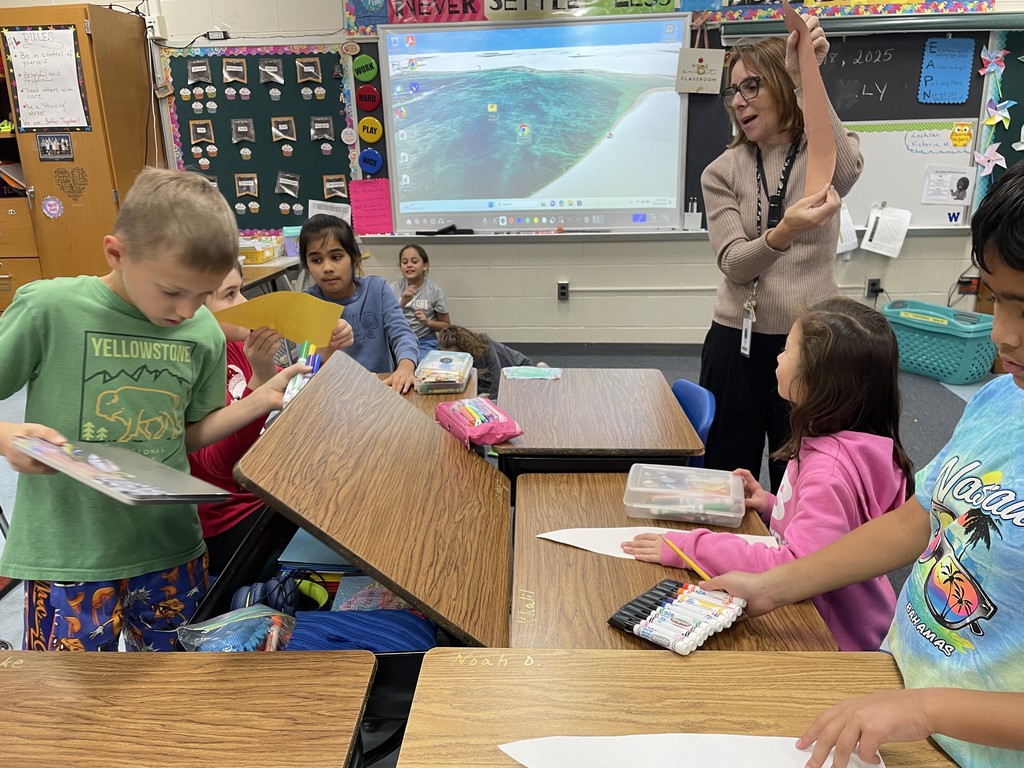 Teacher showing students the paper feather.