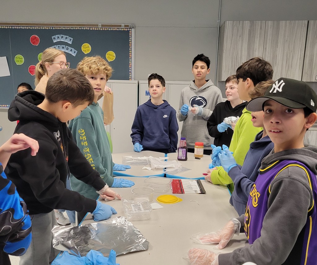 Students standing around table