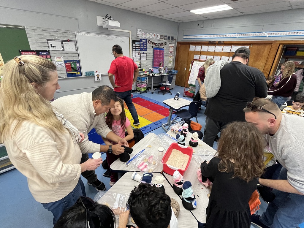 Students and families making sock penguins. 