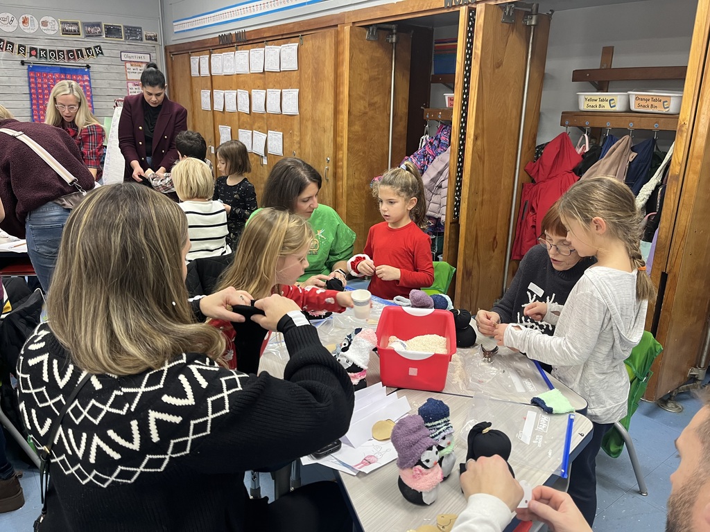 Students and families making sock penguins. 
