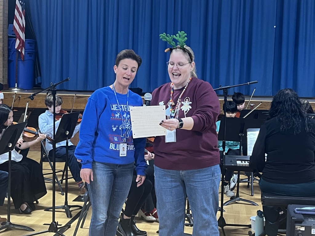 Music teacher and Supervisor of Fine Arts sing together. 