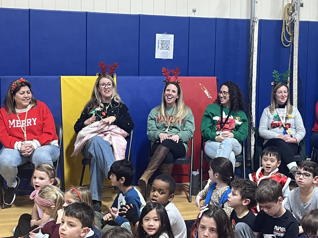 The teachers are dressed for the holiday and enjoying the performance.