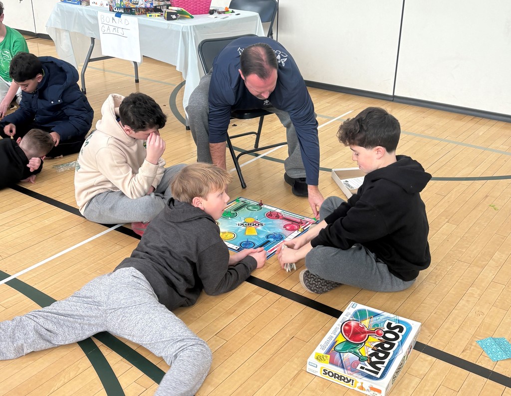 Students playing board games with Mr. Custer 