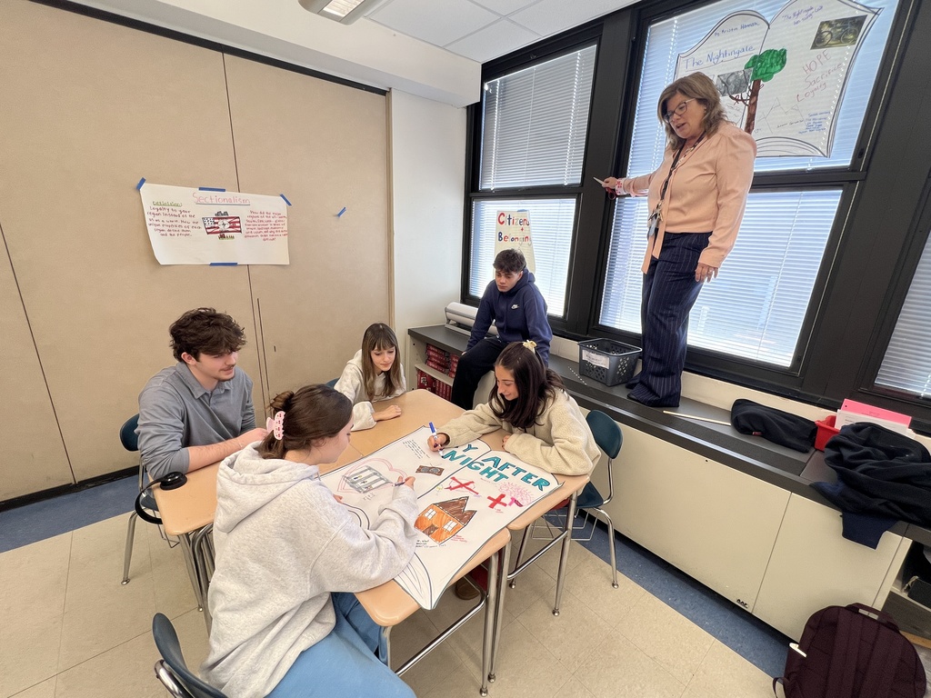 Mrs. Leegan hanging posters up