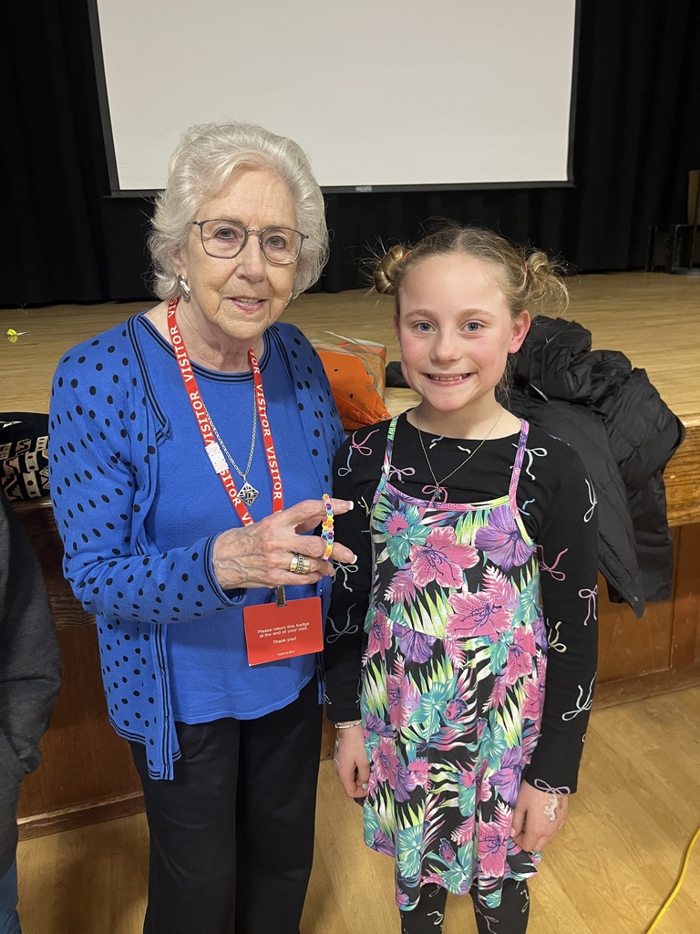 Student gifts the presenter with a handmade bead bracelet.