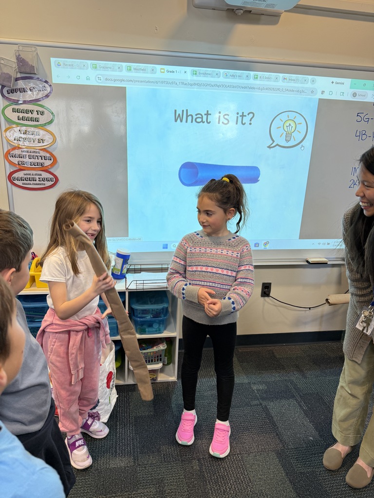 students standing next to one another, one holding a paper tube