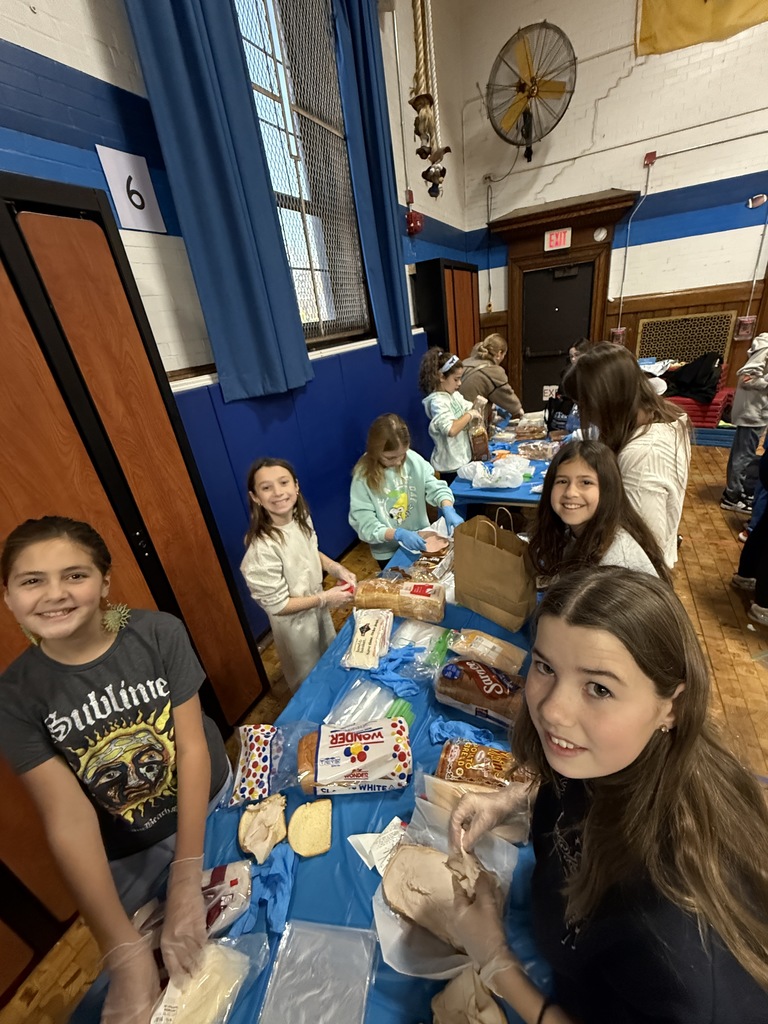 5th grade students standing together while making sandwiches