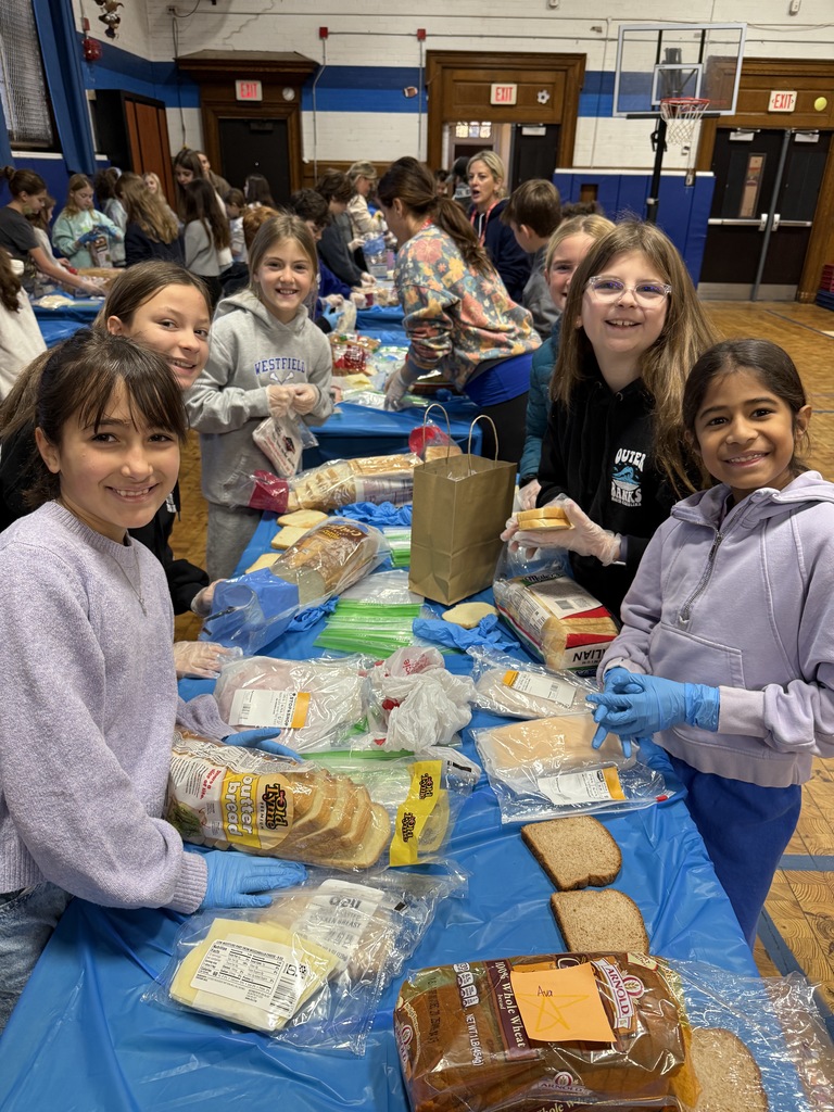 5th grade students standing together while making sandwiches