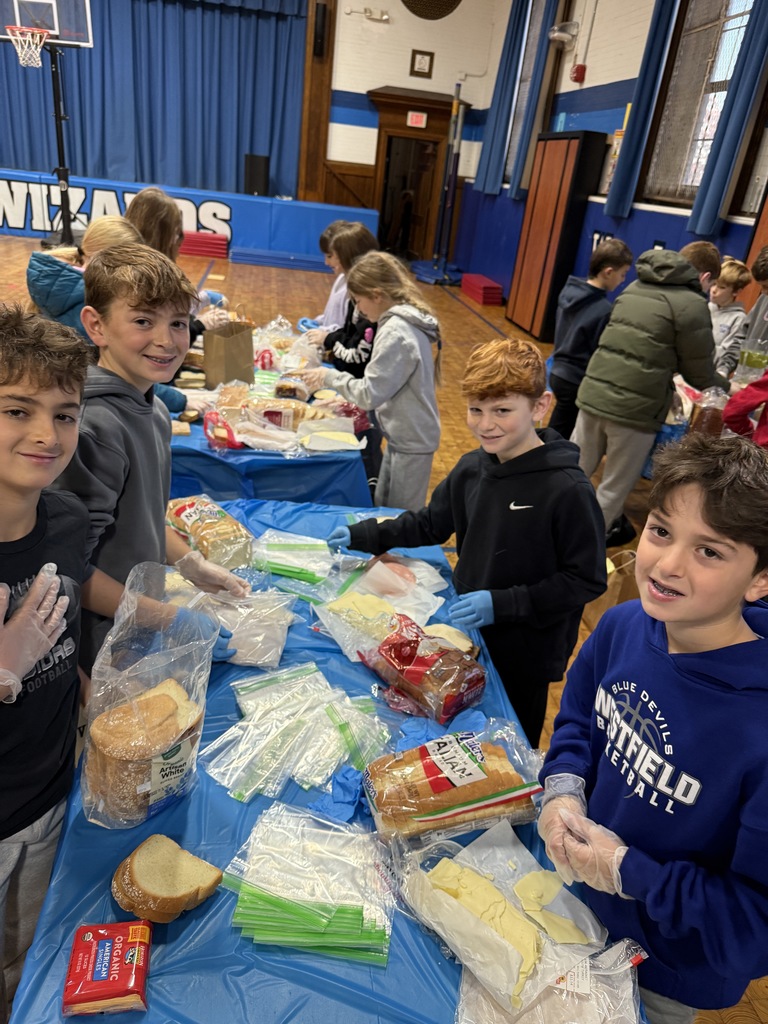 5th grade students standing together while making sandwiches