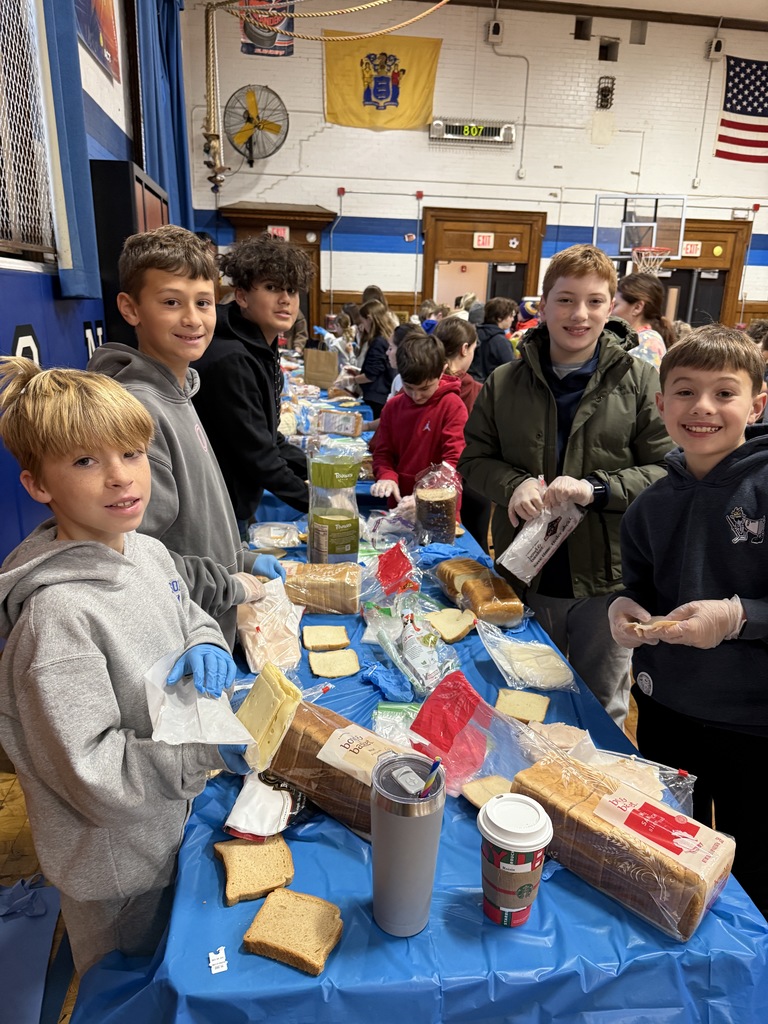 5th grade students standing together while making sandwiches