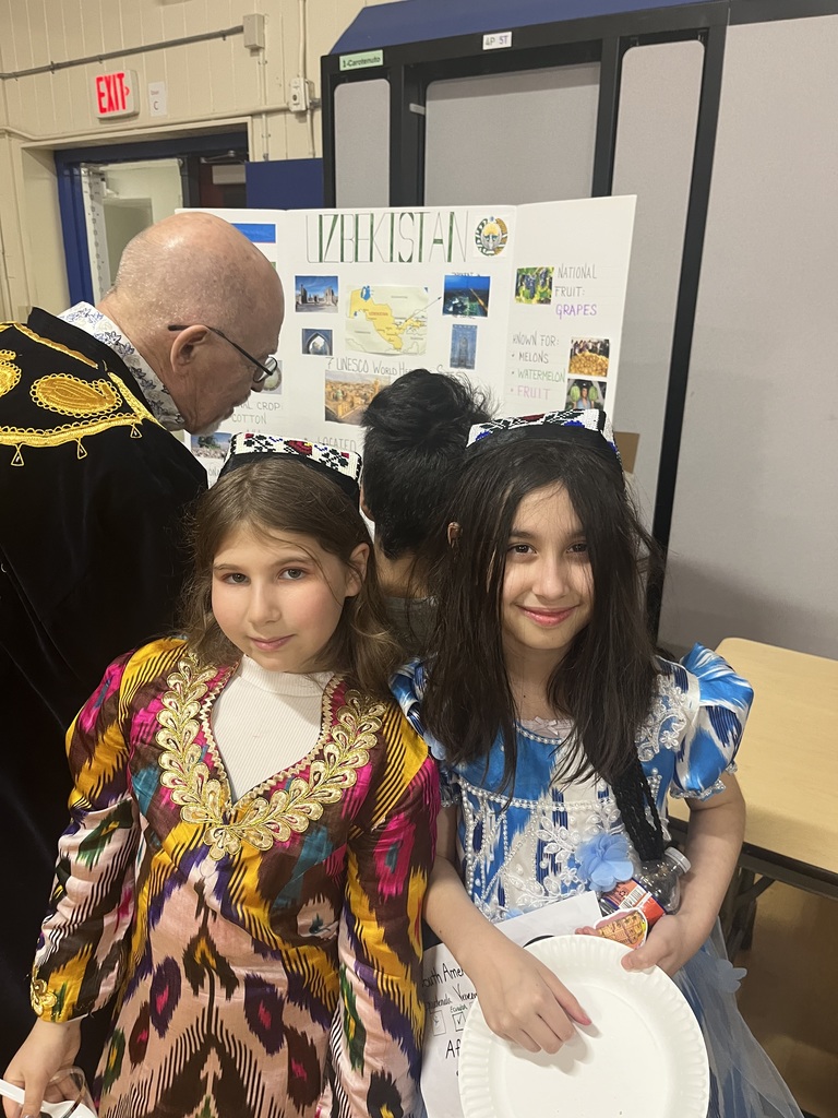 Two students show off their traditional clothing from Uzbekistan.