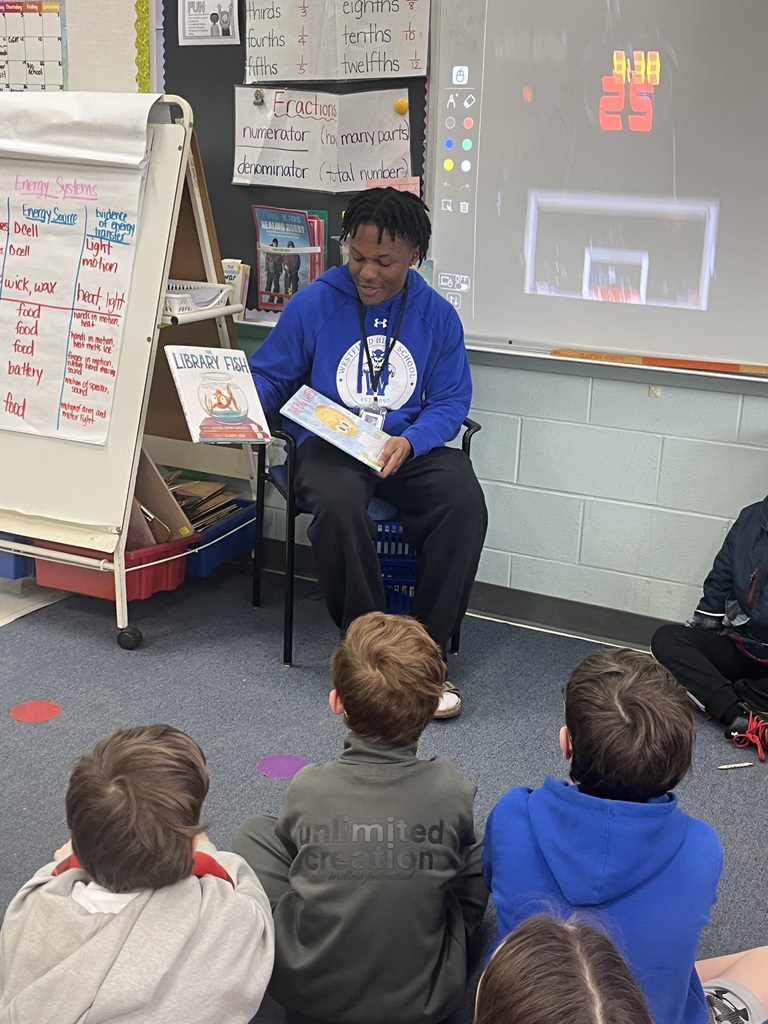WHS football player reads to students.