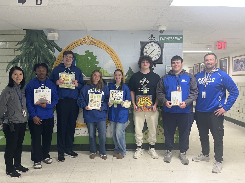 Six WHS football players are photographed with the football coach and principal.