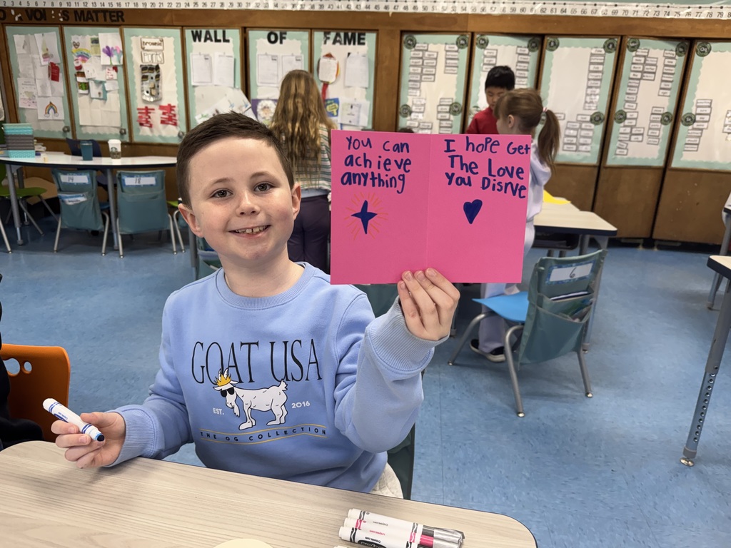 Student proud of the card he made.