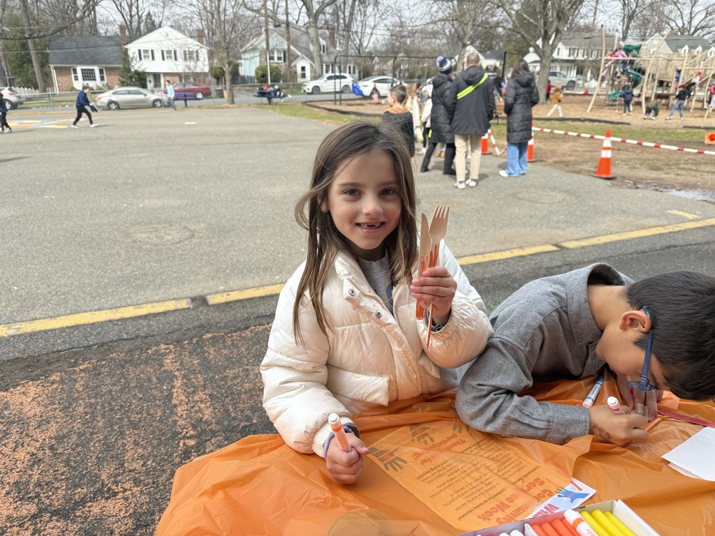 student holding up decorated utensils