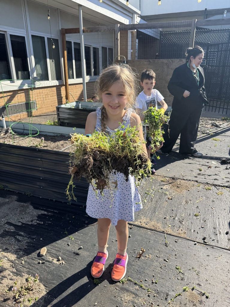 Students show off all the weeds they pulled.