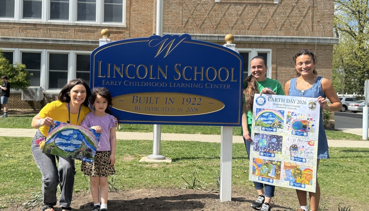 Eliana poses with staff members and her poster