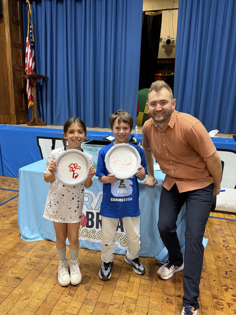 2 students standing with assembly presenter