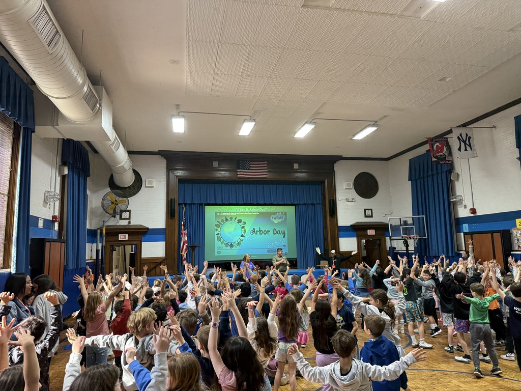 students standing as trees in a forest during Arbor Day assembly