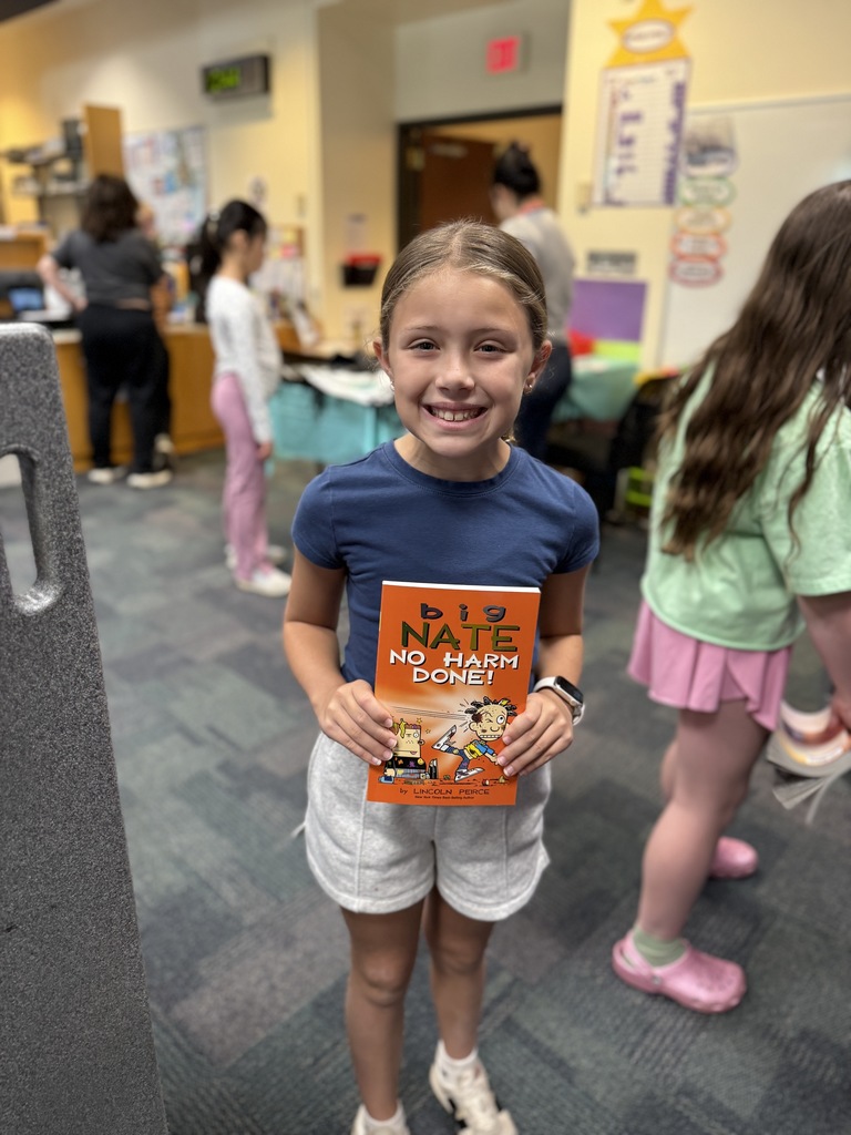 student holding up book at the Book Fair
