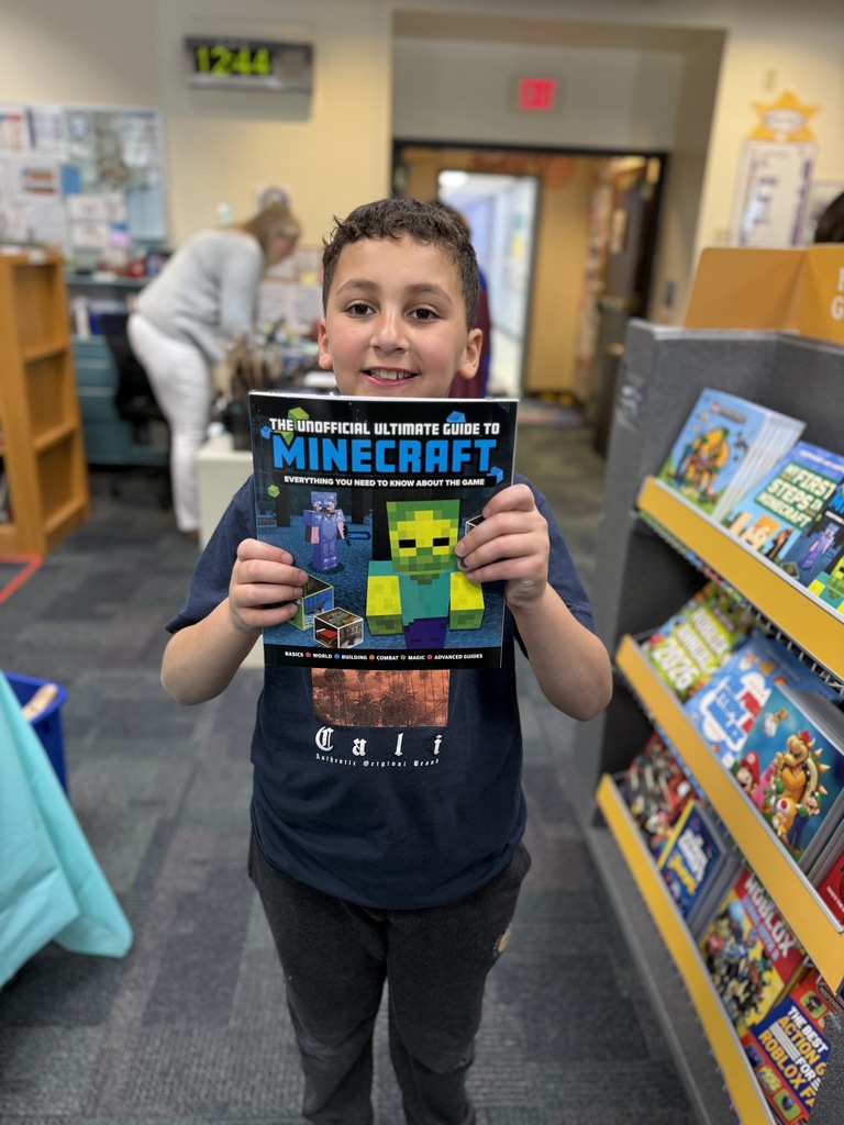 student holding up book at the Book Fair