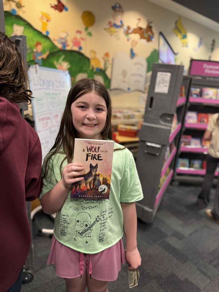 student holding up book at the Book Fair
