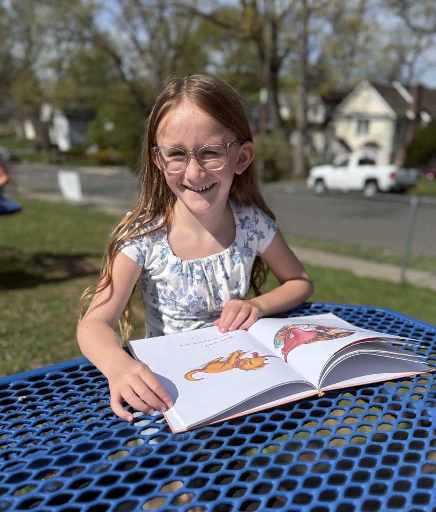 student sitting outside reading