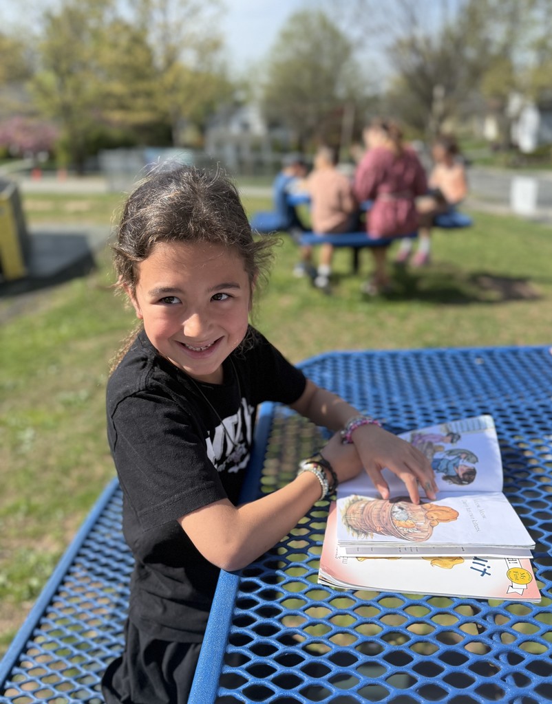 student sitting outside reading