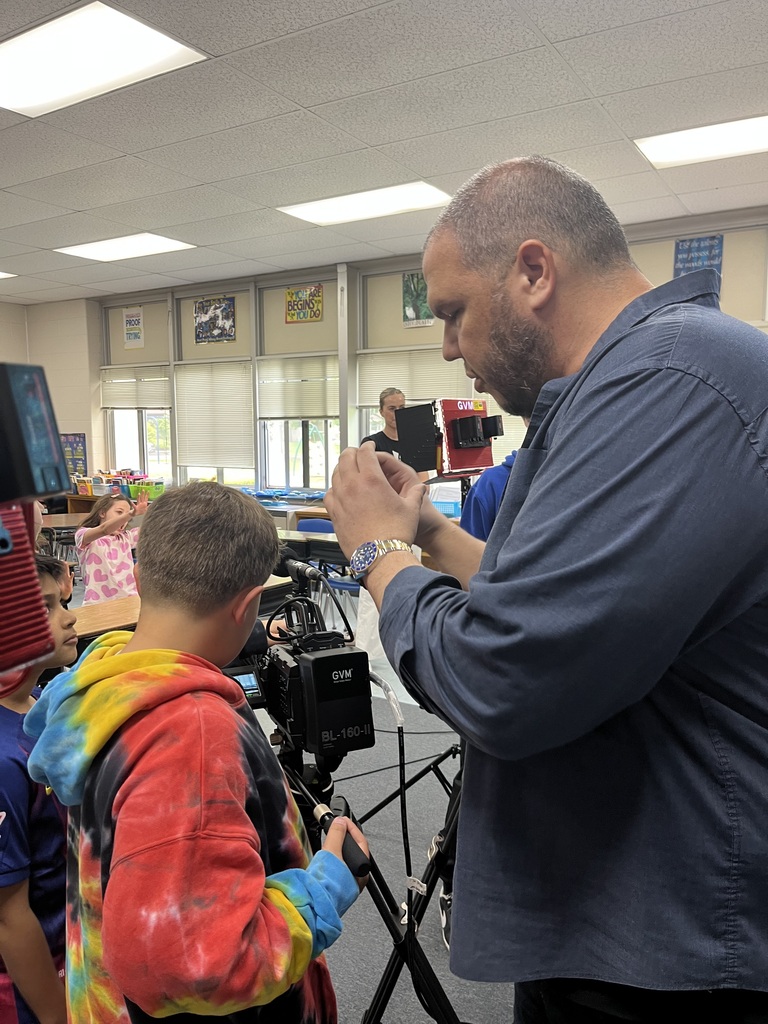 Mr. Alongi guides a student in using the camera.