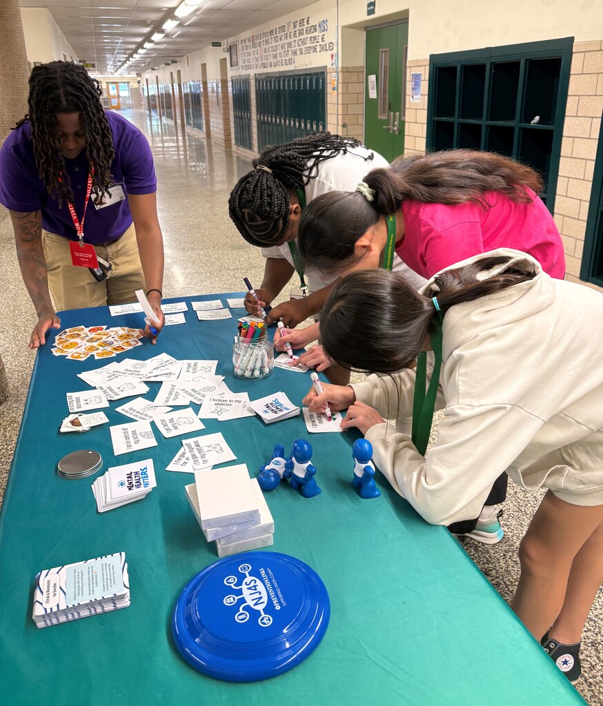 Guests from Prevention Links hosting positive affirmations  table with students