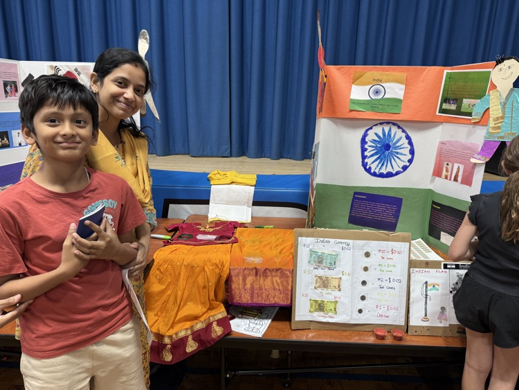 student standing with parent in front of presentation board