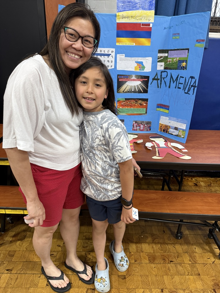 student standing with parent in front of presentation board