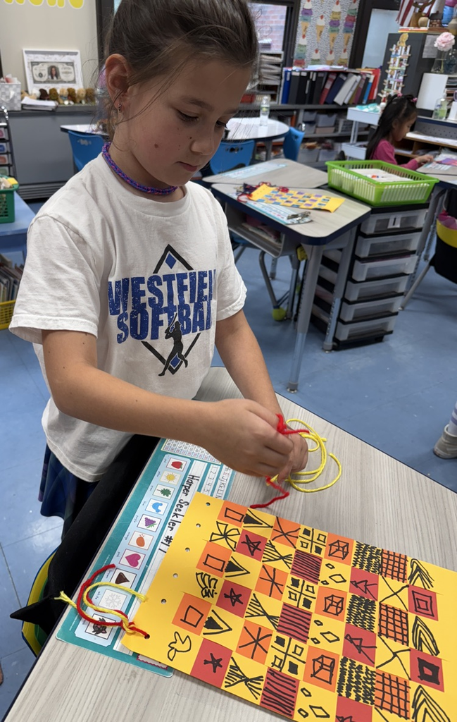 student with their paper weaving project