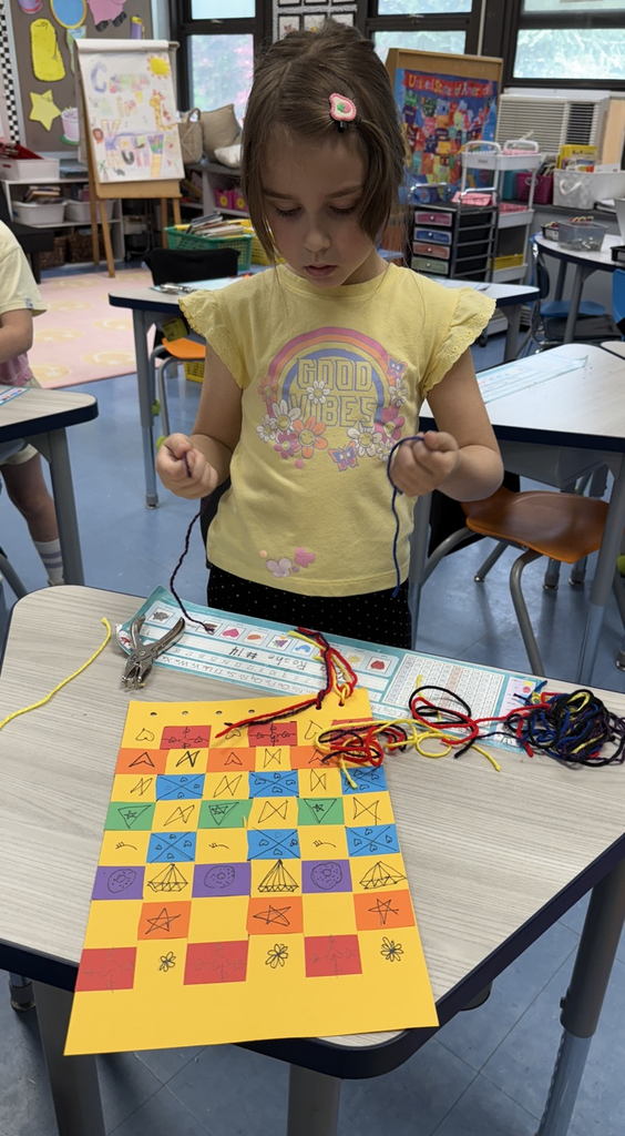 student with their paper weaving project