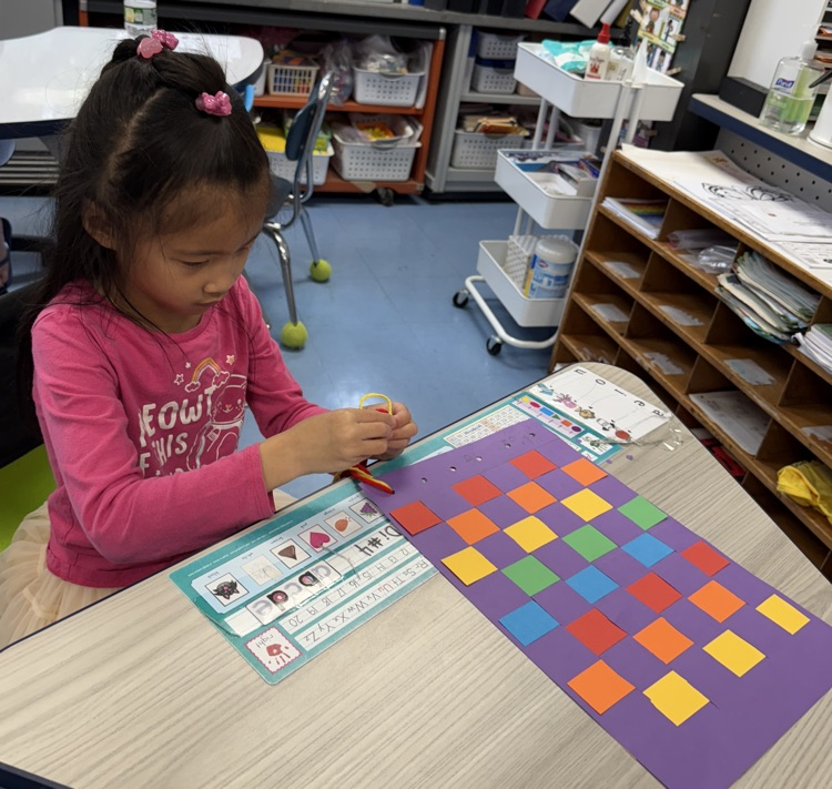 student with their paper weaving project