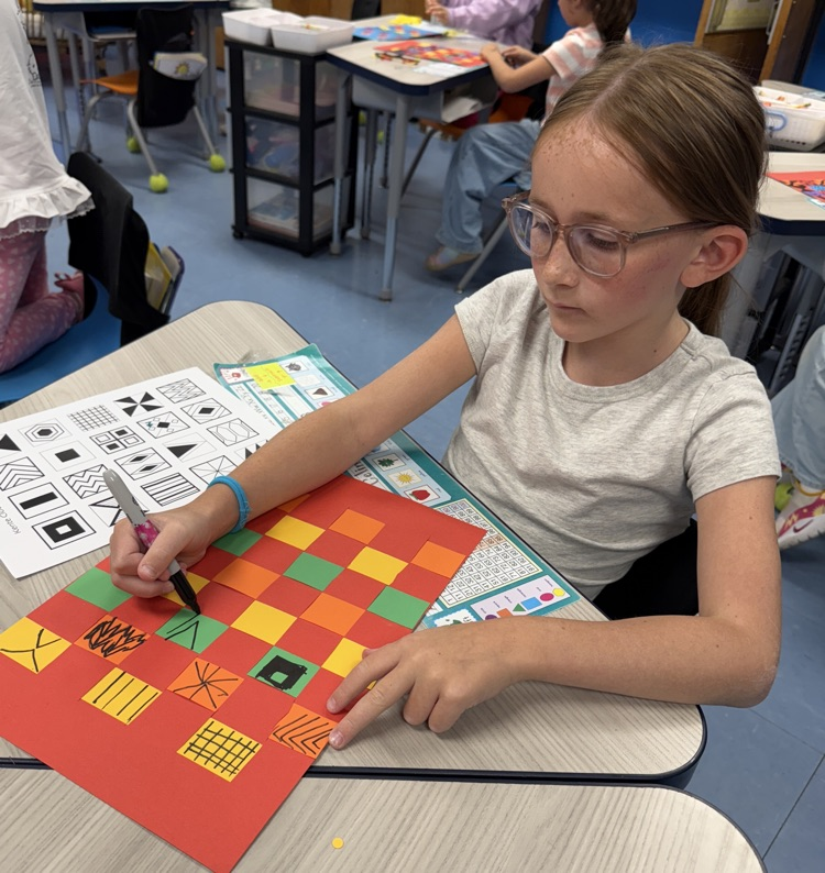 student with their paper weaving project