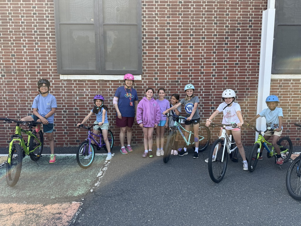 students standing with EZ ride presenter, holding their bikes