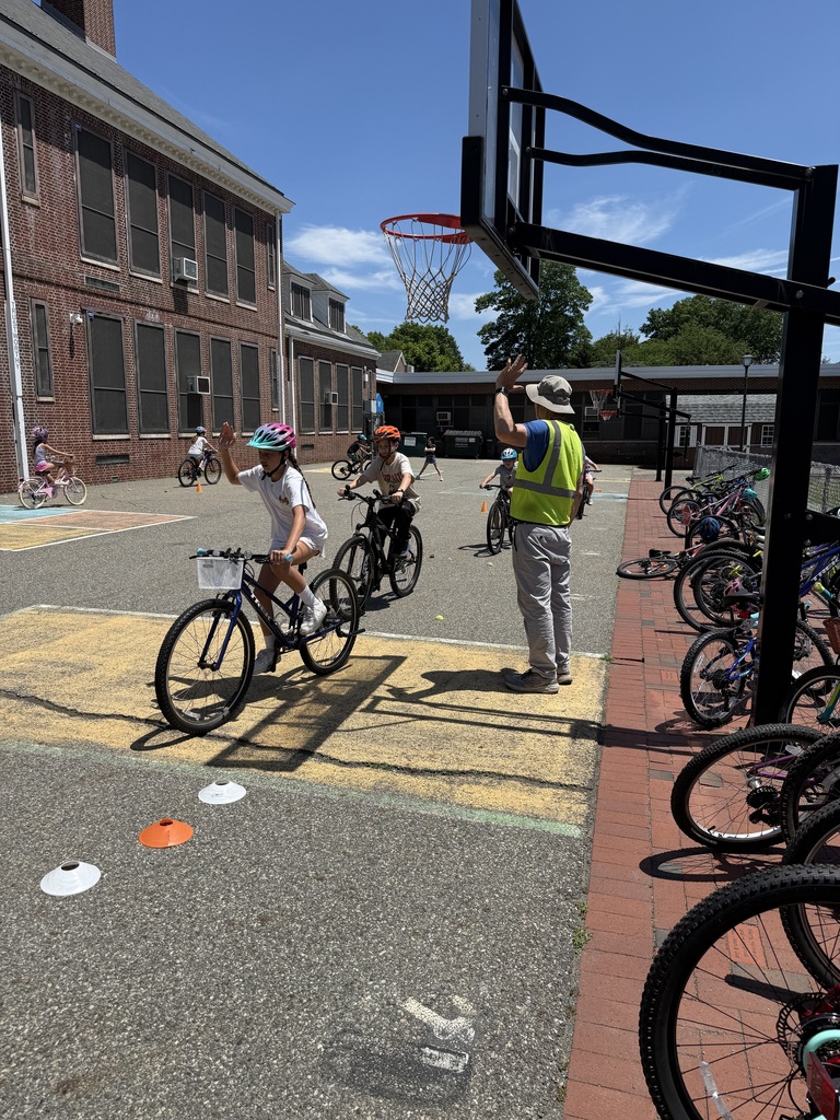 students riding by EZ Ride presenter on bike safety course