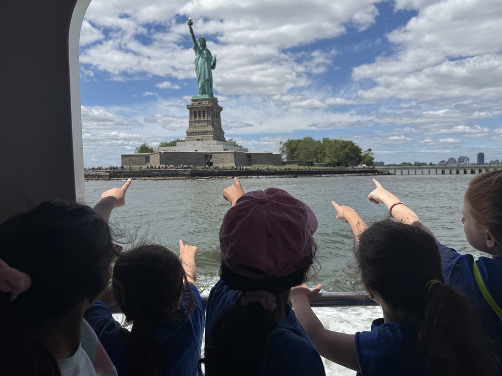 Students excited to see the Statue of Liberty while riding the ferry.