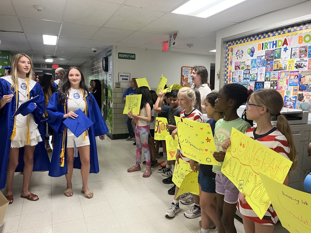 WHS seniors walking through the halls one last time as our students clap and hold up congratulatory signs. 