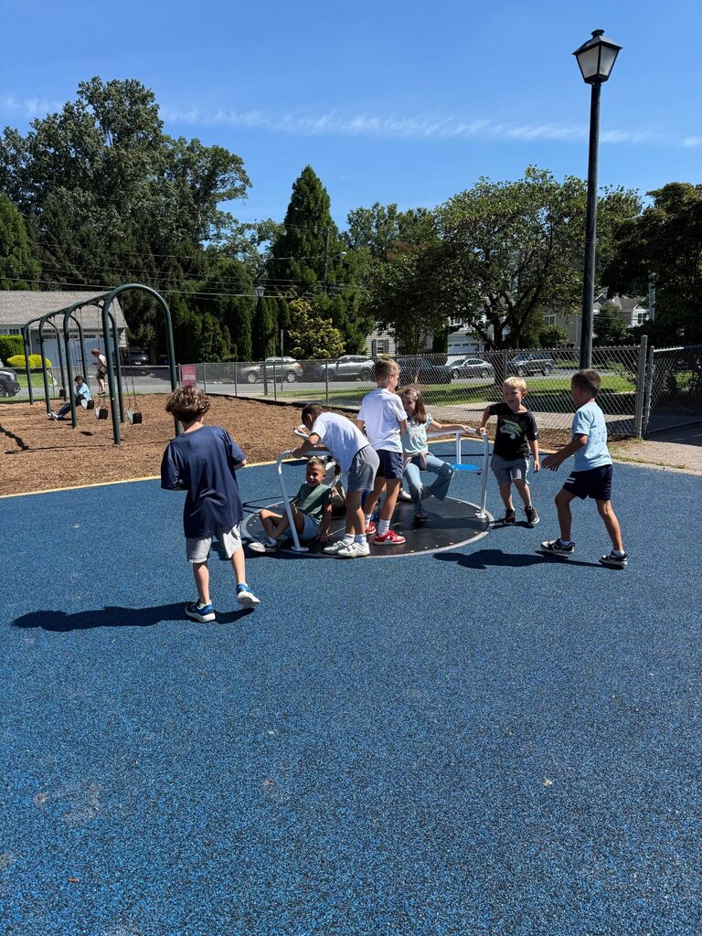 students playing on new playground spinner