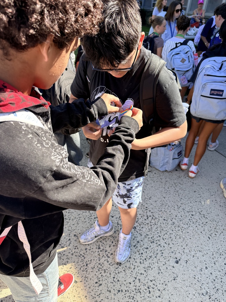 student pinning a ribbon on another student